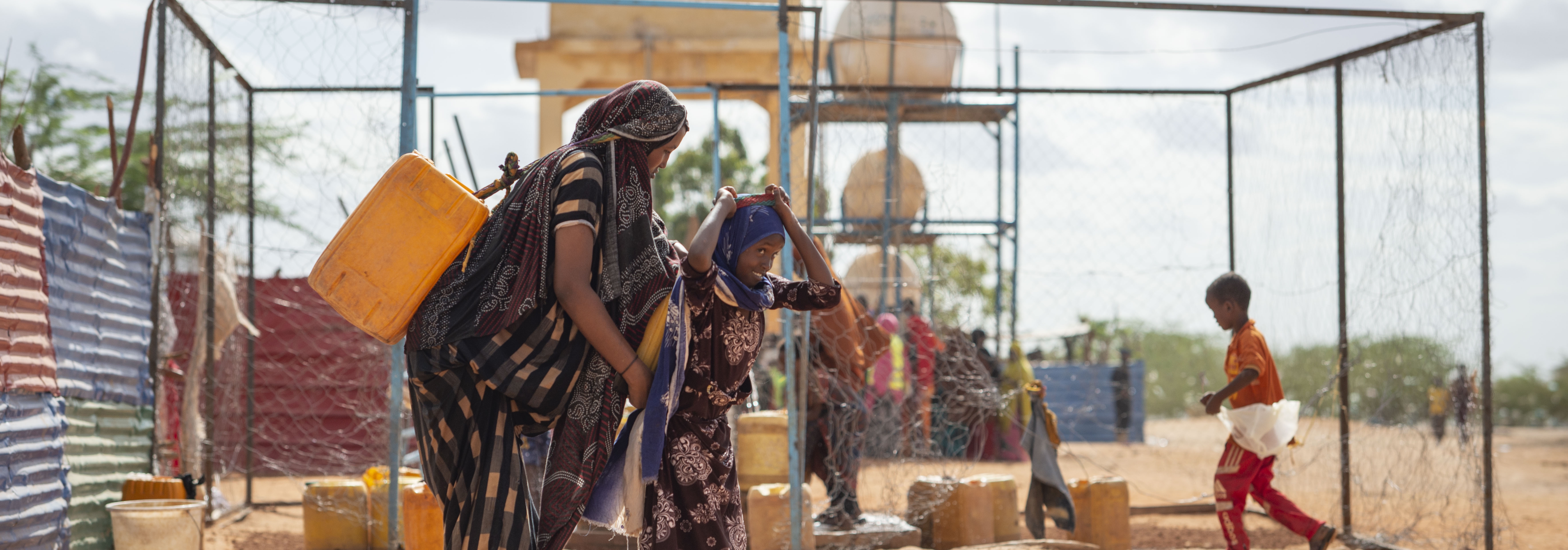 Mother and daughter collect water from one of the sustainable water supplies in Doolow IDP site, Gedo Region. ©IOM 2020