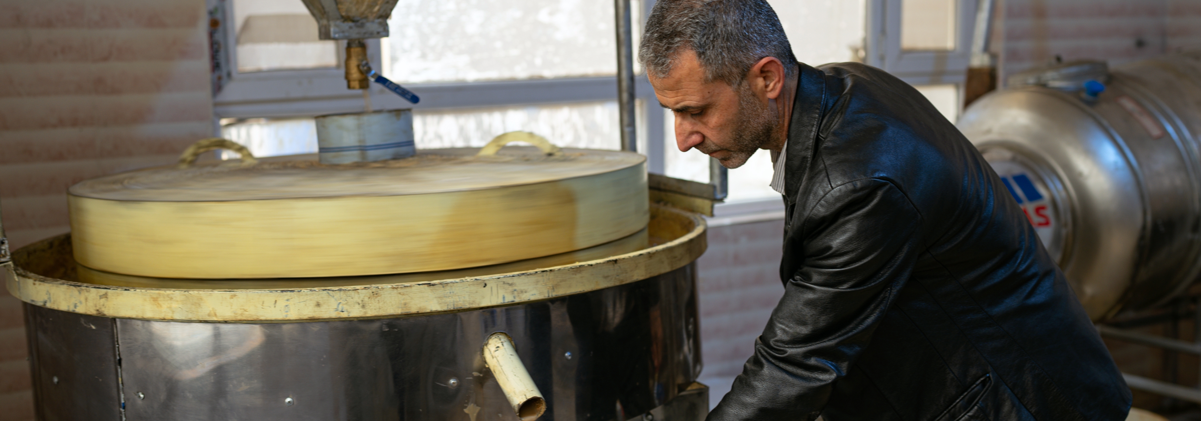 A Syrian man in Erbil, Iraq making traditional desserts through support from an IOM refugee livelihood program. © IOM 2022 