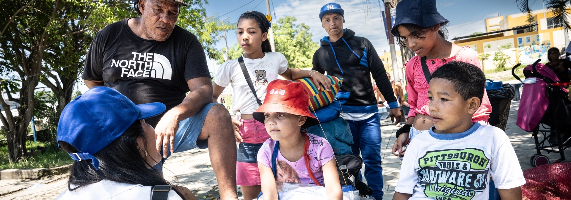 IOM staff provides information to a Venezuelan migrant family, who just arrived at the Peruvian border with Ecuador © Gema Cortes/IOM 2024