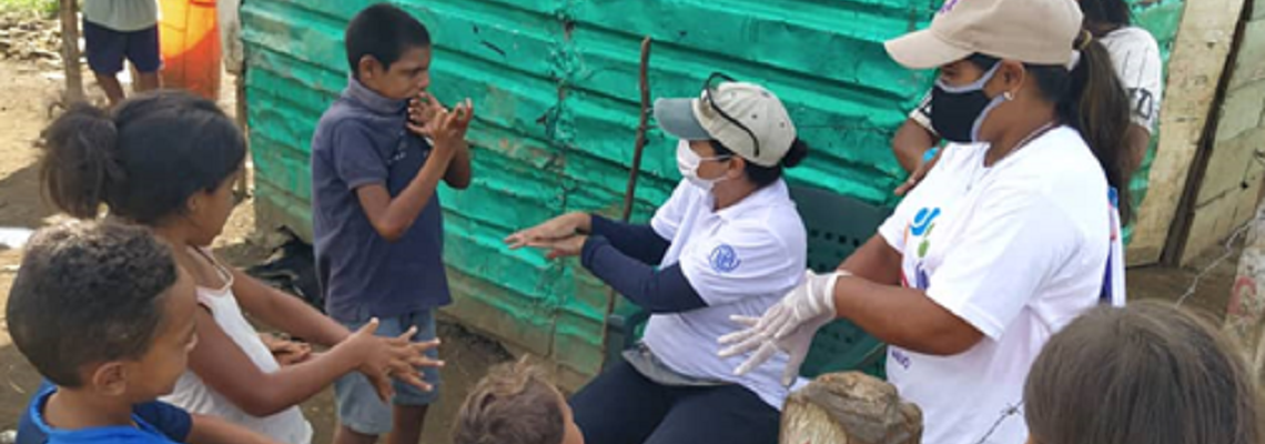 IOM staff providing awareness raising on hand-washing for COVID-19 to children. @ IOM Venezuela/2021