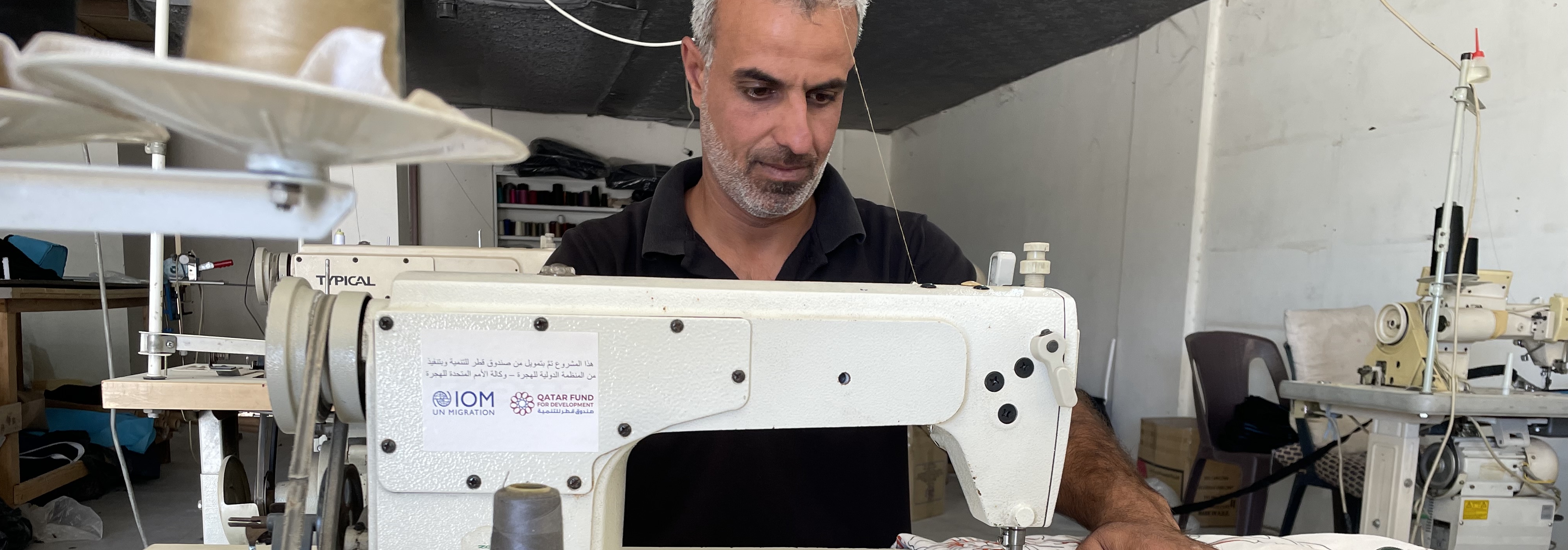A beneficiary of the Individual Livelihood Assistance in Bekaa, using his newly purchased sewing machine through the grant provided by IOM to start up his small business. @ IOM Lebanon 2022.