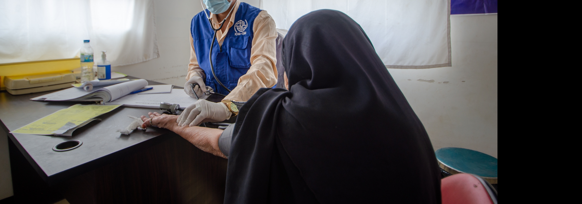 IOM doctor screening an elder displaced woman in a health clinic in a displacement site in Ma’rib, Yemen @ IOM / Rami Ibrahim, 2021