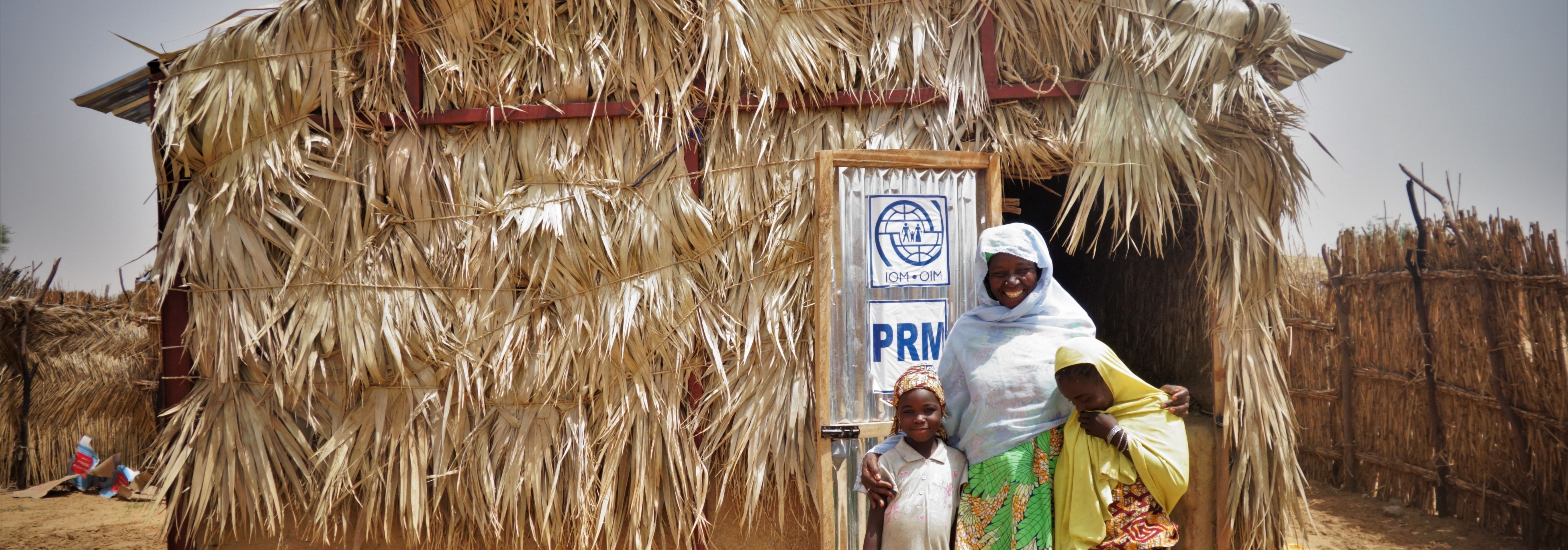 A woman standing in front of her newly constructed shelter in Diffa, Niger. @ IOM, 2021