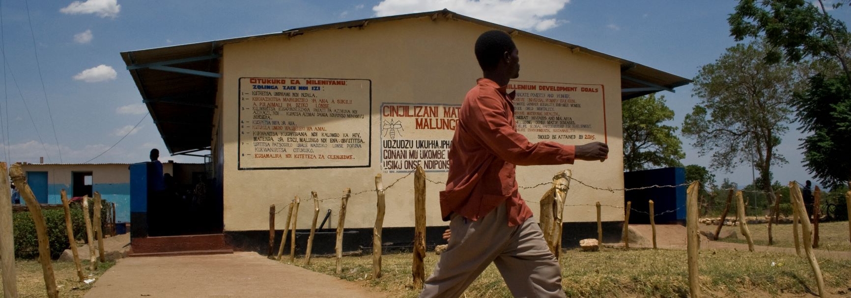 A man walks by a health clinic in Katete in eastern Zambia. Credit Mpho Seleka